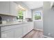 Bright kitchen featuring white cabinets, marble counters, and stainless steel sink at 4809 Allisonville Rd, Indianapolis, IN 46205