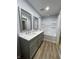 Bright bathroom with wood-look vinyl flooring, double sinks, framed mirrors, and a shower-tub combo at 5725 W 200 N, Lebanon, IN 46052