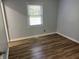 Bright bedroom features wood-look flooring, neutral walls, and a window letting in natural light at 5725 W 200 N, Lebanon, IN 46052