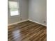 Clean bedroom features modern wood-look flooring, neutral walls, and a window with natural light at 5725 W 200 N, Lebanon, IN 46052