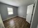 Empty bedroom with wood-look floors, a window, and door at 5725 W 200 N, Lebanon, IN 46052