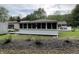 Exterior view of the home highlighting the sun room with a large yard and covered porch at 5725 W 200 N, Lebanon, IN 46052