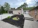 Landscaped exterior with mulch beds, flower planters, and a walkway leading to a detached garage at 5725 W 200 N, Lebanon, IN 46052