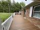 Spacious wooden front porch with white railings, offering an inviting outdoor living area with seating at 5725 W 200 N, Lebanon, IN 46052