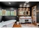 Modern bathroom featuring dual sinks, a soaking tub, and exposed brick, offering a luxurious and relaxing space at 584 S 10Th St, Noblesville, IN 46060