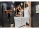 Stylish bathroom vanity featuring a marble countertop, decorative mirror, and dark walls, offering a modern aesthetic at 584 S 10Th St, Noblesville, IN 46060