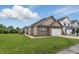A beige vinyl-sided single-Gathering home with a two-car garage, lawn, and sidewalk near neighboring homes at 608 Fisher Creek Dr, Indianapolis, IN 46239