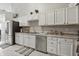Well-lit kitchen with white cabinets, stainless steel appliances, and stylish marble flooring at 608 Fisher Creek Dr, Indianapolis, IN 46239
