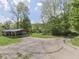 Exterior view of a house surrounded by trees and greenery, featuring a covered carport for parking at 6091 Mt Moriah Rd, Nineveh, IN 46164