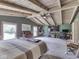 This stunning bedroom boasts high, beamed ceilings, a ceiling fan, and a cozy sitting area with a fireplace, providing ample space at 6091 Mt Moriah Rd, Nineveh, IN 46164