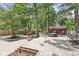 View of the expansive backyard with deck, fire pit, mature trees, and shed at 6110 Orinoco Ave, Indianapolis, IN 46227