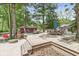 This backyard has a wooden deck with seating and a fire pit, nestled among mature trees at 6110 Orinoco Ave, Indianapolis, IN 46227