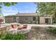 A charming backyard shows a patio, a small wood deck and a grey brick house at 6110 Orinoco Ave, Indianapolis, IN 46227