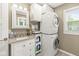 Modern bathroom featuring a stacked washer/dryer unit and white vanity with granite top at 6110 Orinoco Ave, Indianapolis, IN 46227
