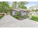 View of the home from the driveway surrounded by lush landscaping at 6110 Orinoco Ave, Indianapolis, IN 46227