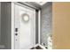 Inviting front door with frosted glass and a wreath, complemented by a gray brick wall at 6110 Orinoco Ave, Indianapolis, IN 46227