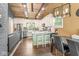 Open-concept kitchen and dining area with an island, stainless appliances, and wood-beamed ceiling at 6110 Orinoco Ave, Indianapolis, IN 46227