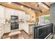 Modern kitchen with stainless steel appliances, wooden ceiling beams, and plenty of natural light at 6110 Orinoco Ave, Indianapolis, IN 46227