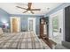 Bright main bedroom with hardwood floors, blue walls, ceiling fan, dresser, and patio access at 6110 Orinoco Ave, Indianapolis, IN 46227