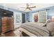 Comfortable main bedroom with blue walls, a ceiling fan, and a sliding barn door to the walk-in closet at 6110 Orinoco Ave, Indianapolis, IN 46227