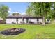 Spacious backyard featuring a fire pit, deck with furniture, grill, and mature trees at 620 Meadows Dr, Mooresville, IN 46158