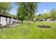 Large, well-maintained backyard features a fire pit, patio, playset and mature trees at 620 Meadows Dr, Mooresville, IN 46158