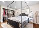 A bedroom features a four-poster bed and an open closet with built in shelving and dresser at 620 Meadows Dr, Mooresville, IN 46158