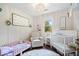 Bedroom with crib, toddler bed, rocking chair, and soft decor for a cozy atmosphere at 620 Meadows Dr, Mooresville, IN 46158