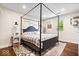 Charming bedroom featuring a four-poster bed, soft rug, and natural light at 620 Meadows Dr, Mooresville, IN 46158