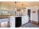 Modern kitchen with an island, white cabinets, wooden ceiling, and hardwood floors at 620 Meadows Dr, Mooresville, IN 46158