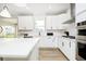 Modern kitchen with island, stainless appliances, white cabinets, and a window overlooking the yard at 6421 Springtide Ct, Plainfield, IN 46168