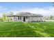 Grassy backyard featuring a covered patio and lush landscaping, perfect for outdoor relaxation and entertaining, shaded by mature trees at 6465 Wasco Dr, Whitestown, IN 46075