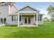 Inviting backyard with covered patio, lush green lawn, and charming flower pots, creating a delightful outdoor retreat at 6465 Wasco Dr, Whitestown, IN 46075