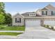 New townhome features a two-car garage, brick facade, and manicured lawn at 6465 Wasco Dr, Whitestown, IN 46075