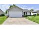 Charming single-story home with a two-car garage and well-manicured lawn and a concrete driveway at 6556 Wandering Way, Indianapolis, IN 46241