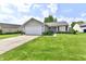 Inviting single-story home with a neat front lawn, attached garage, and quaint front entrance at 6556 Wandering Way, Indianapolis, IN 46241