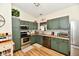 Cozy kitchen with stainless steel appliances, warm wood countertops, and green cabinets at 6556 Wandering Way, Indianapolis, IN 46241
