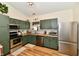 Cozy kitchen featuring stainless steel appliances, green cabinets, and a bright, inviting atmosphere at 6556 Wandering Way, Indianapolis, IN 46241