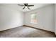 This bedroom has neutral carpet, a ceiling fan, and a window letting in natural light at 6715 Wandering Way, Indianapolis, IN 46241