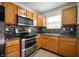 Modern kitchen with stainless steel appliances, oak cabinets and mosaic tile backsplash at 6715 Wandering Way, Indianapolis, IN 46241