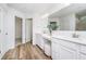 Bright bathroom featuring double sink vanity with white cabinets, quartz counters, wood floor, and walk-in closet at 6833 Jacone Dr, Brownsburg, IN 46112