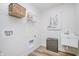 Functional laundry room featuring utility sink, wall mounted wire shelving, decor art, and front load washer dryer hookups at 6833 Jacone Dr, Brownsburg, IN 46112