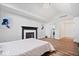 Bedroom featuring a fireplace, light-colored wood floors, and modern decor at 7056 E 171St St, Noblesville, IN 46062