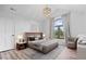 Staged bedroom with white vaulted ceilings, a modern chandelier, and hardwood floors at 7056 E 171St St, Noblesville, IN 46062