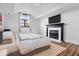 Cozy bedroom featuring fireplace with black mantle, hardwood floors, and a statement window at 7056 E 171St St, Noblesville, IN 46062