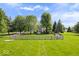 Charming home with a well-manicured lawn, surrounded by mature trees and a classic wooden fence at 7056 E 171St St, Noblesville, IN 46062