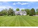 Well-manicured front lawn leading to a charming two-story home under a partly cloudy sky at 7056 E 171St St, Noblesville, IN 46062