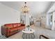 Open concept living area with wood floors, a modern chandelier, and a clear view into the kitchen at 7056 E 171St St, Noblesville, IN 46062