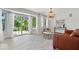 Sunlit living room featuring wood floors, white walls, and large windows with sheer curtains at 7056 E 171St St, Noblesville, IN 46062