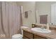 Well-lit bathroom with a shower curtain, toilet, and vanity with a sink and decorative accents at 7242 Blue Ridge Dr, Noblesville, IN 46062